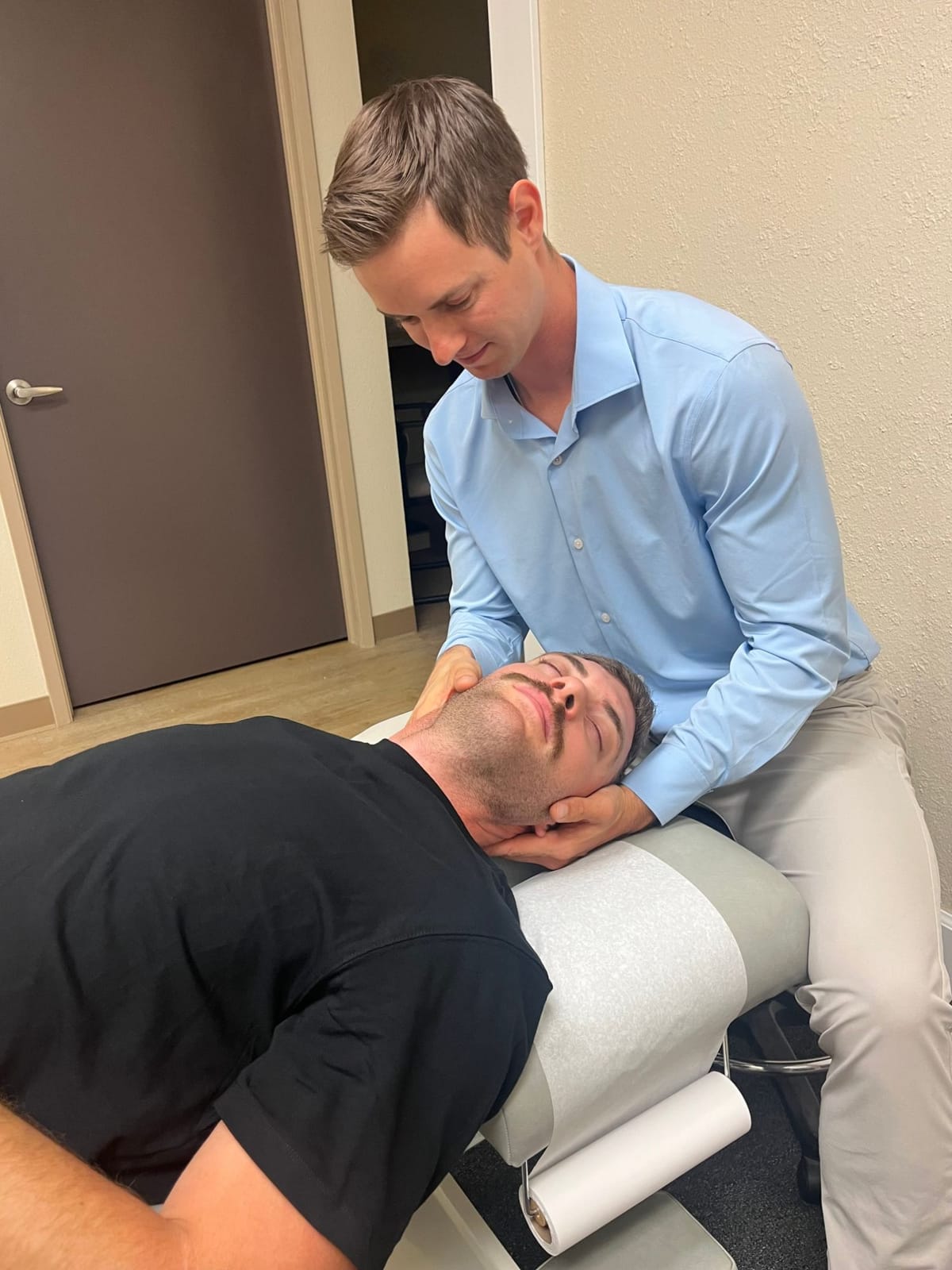 Dr. Hill cradling a patient's head and neck during a cervical adjustment